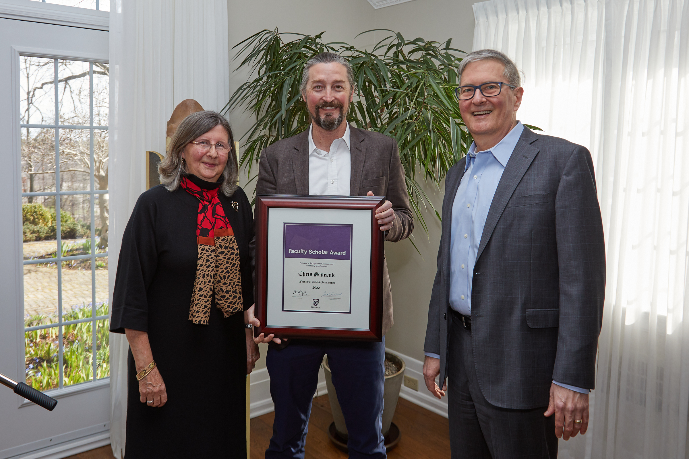 Chris Smeenk holds his faculty scholar award with Sarah Pritchard, and Alan Shepard, Western University Provost and President, respectively