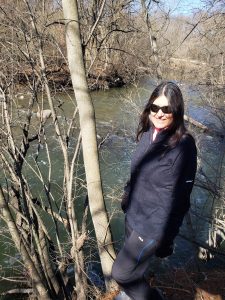 Deborah McGregor stoning beside a river