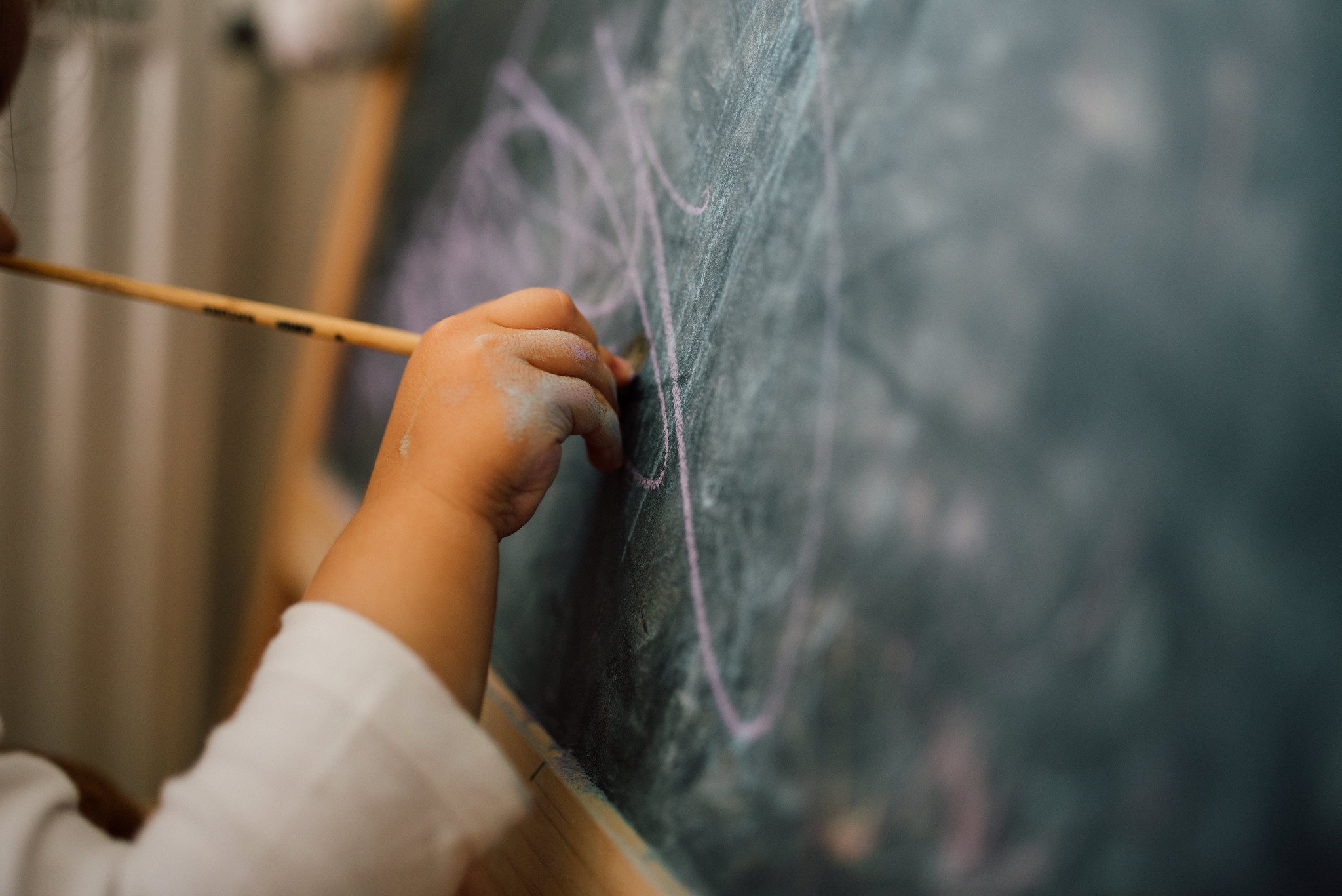 Child scribbling on a chalkboard