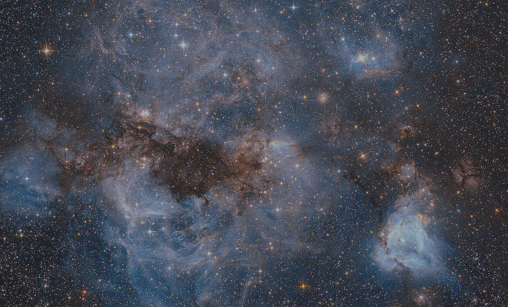 Blue starry sky with orange and light blue clouds