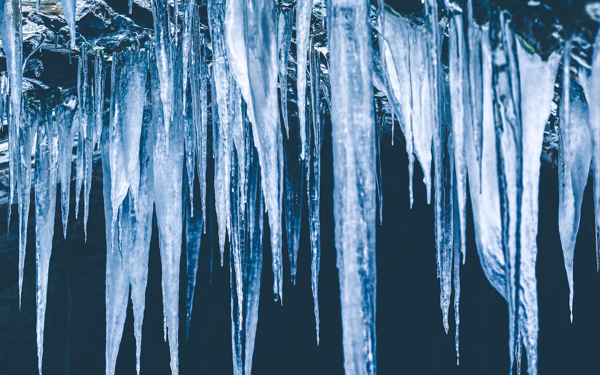 Cluster of icicles pictured in front of a dark blue background